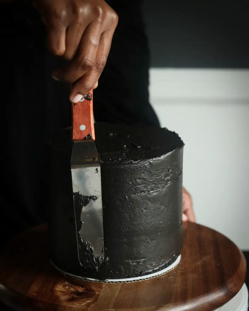 Frosting a Black Halloween Cake.